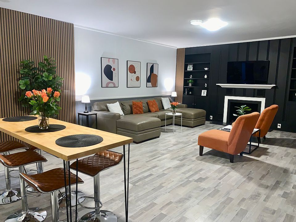 Modern open-plan living room with a stylish leather sofa that pulls out into a full-size bed, flat-screen TV, and plenty of space to relax or entertain.