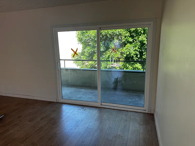 Living Room view of Access to LARGE Private Patio, showing trees providing privacy. New Curtains not shown in this photo. Will be updated