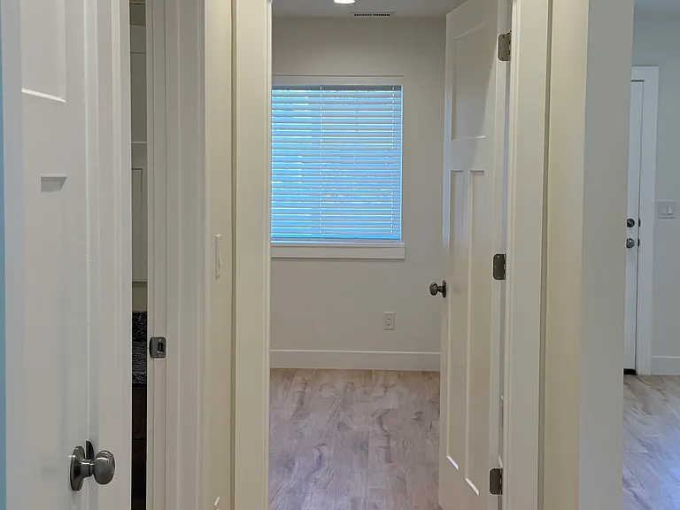 Hallway between bedroom 2 and 3, connecting the main full bath and a linen closet.