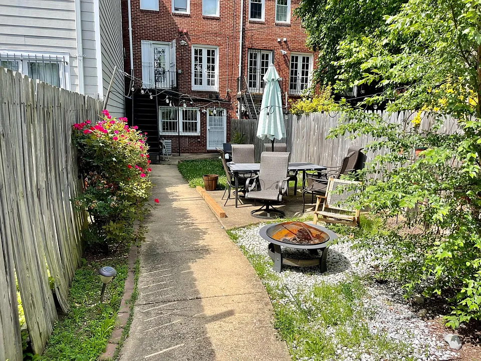 Holy backyard! Firepit, grass, BBQ, patio furniture and more! Lower door is to the back of unit