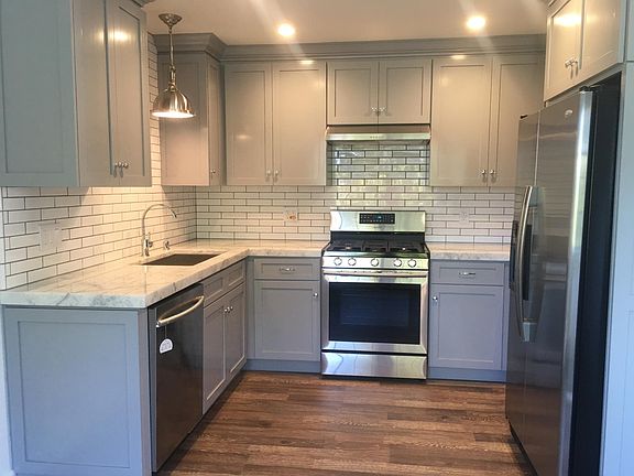 Gray shaker style cabinets w/ quartzite countertops