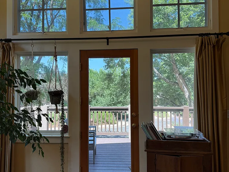 Living room looking out to north deck. Swing and chairs on deck.