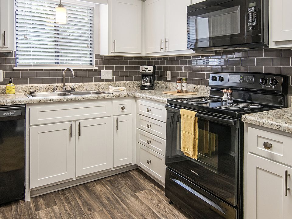 Kitchen with black appliances and white cabinetry at Magnolia Crossing apartments for rent in Macon, GA