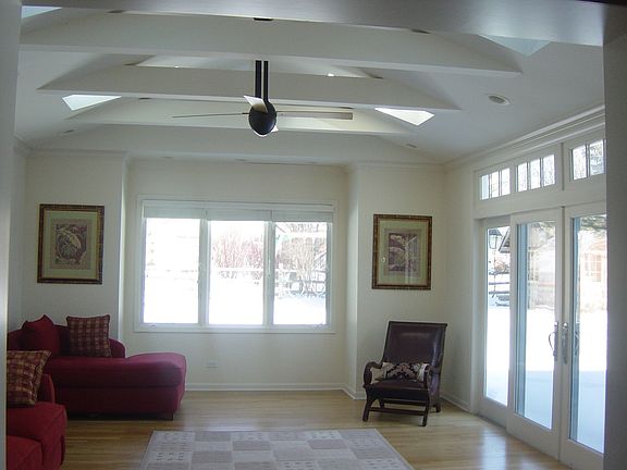 Bright sunroom with heated floor overlooking beautiful backyard