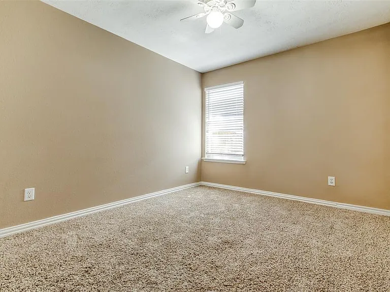 Third bedroom has ceiling fan, comfortable carpet, window and clothes closet.