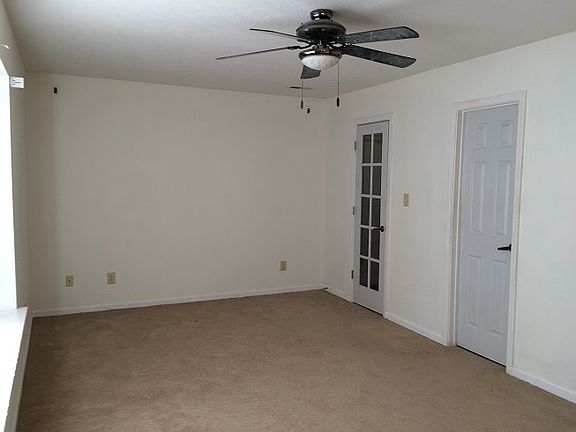 Master bedroom with wide window, ceiling fan and extra light