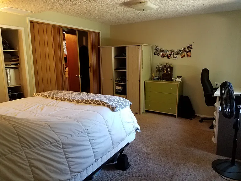 Bedroom. Access to laundry room through closet. Photos show the unit furnished by previous tenants; the unit will be delivered vacant.