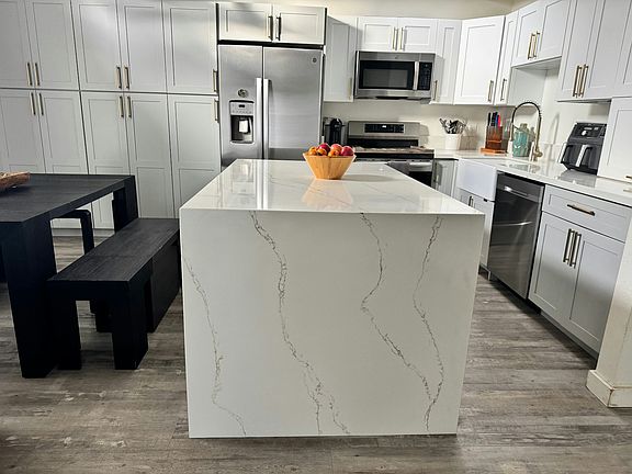 Beautiful remodeled open-concept living area with center stand dividing dining area and kitchen
