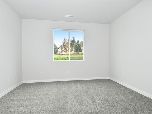 The master bedroom is spacious with a large window.