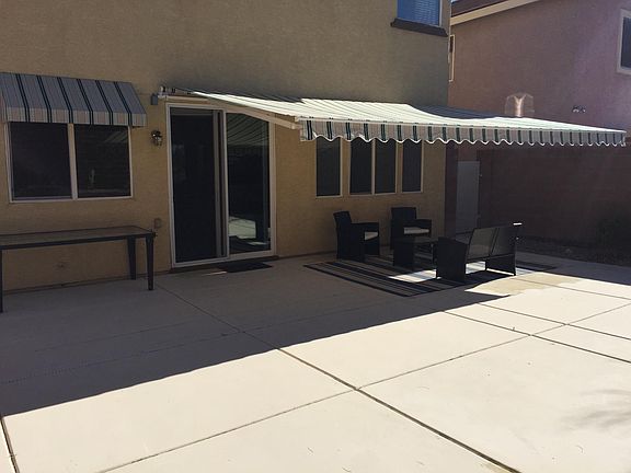 Backyard with furniture and retractable awning.