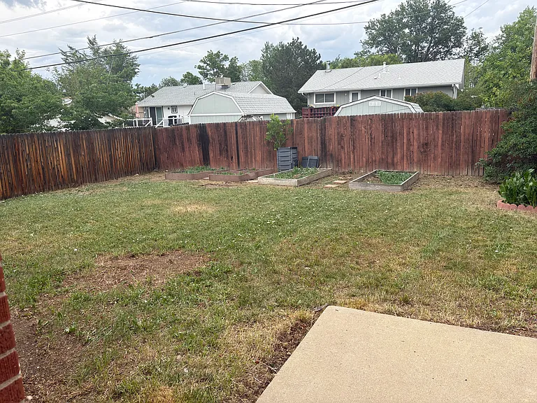 large fenced backyard with in ground planters