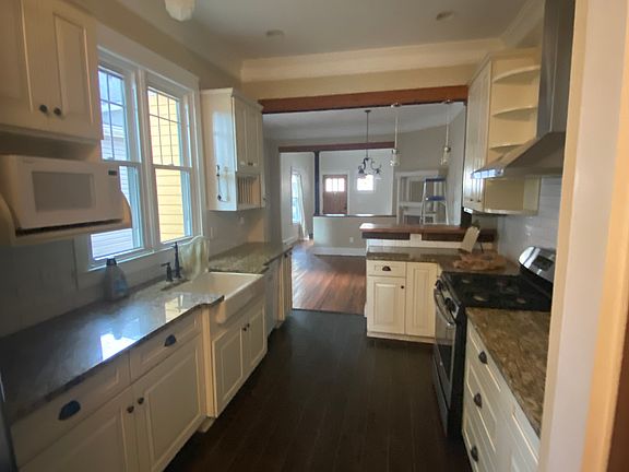 Galley kitchen with pantry and utility closet.