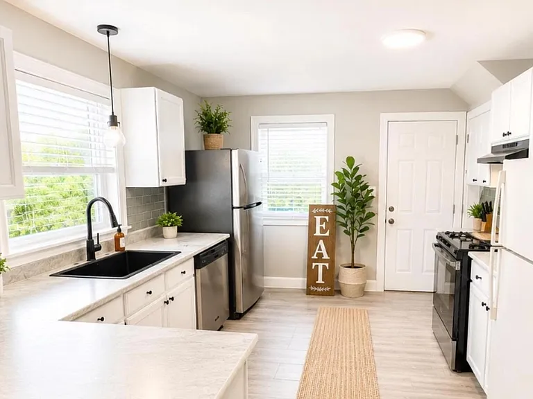 Galley kitchen with ample cabinet storage, generous counters, double sink, and full appliance package for easy meal prep.
