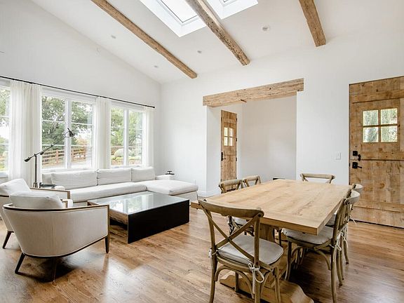 reclaimed entry and side dutch barn doors with lites connect indoor and outdoor spaces seamlessly