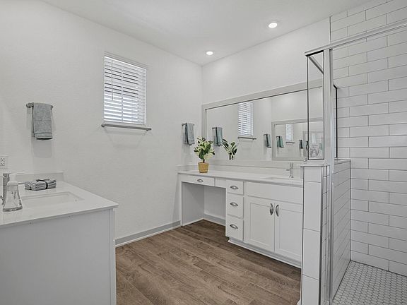 Primary bathroom has split vanities and large single shower
