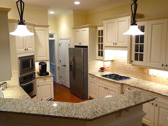 This kitchen with granite countertops and bar top is open to the Family and Breakfast Rooms