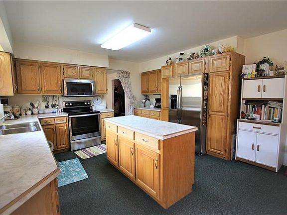 INCREDIBLE 21x14 Eat-in Kitchen w/ Convenient Island & Plenty of Newer Wood Cabinets, Double Stainless Steel Sink & Newer Stainless Steel Appliances included!