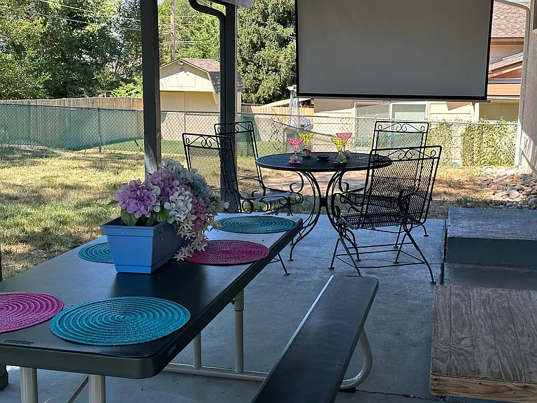 Your private backyard escape with cozy seating, a dining table, and a projector for ultimate relaxation!