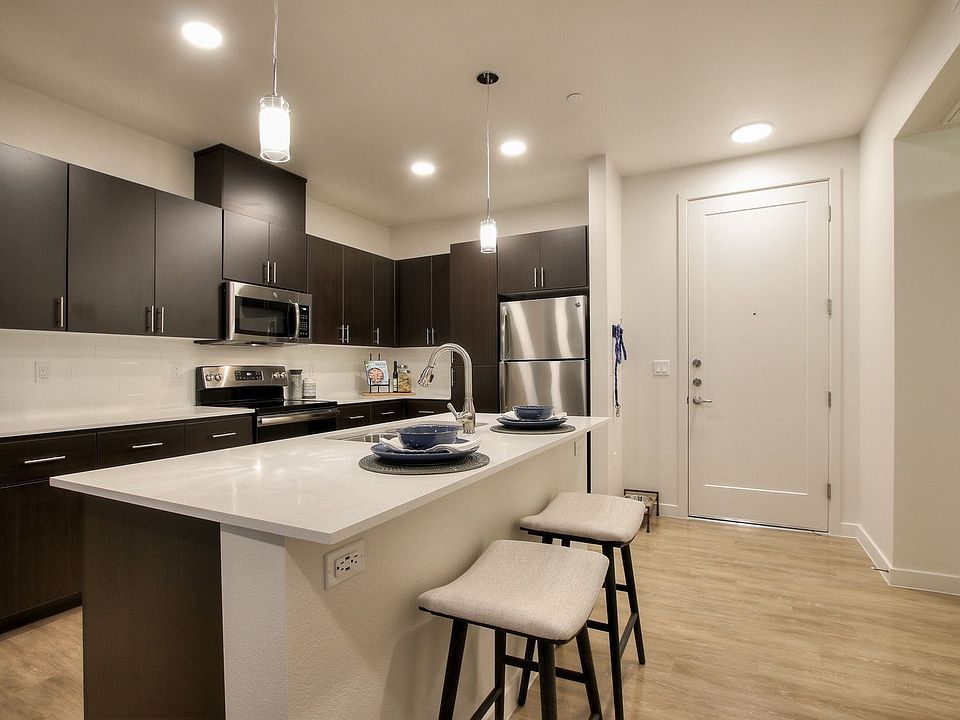 Large kitchen with kitchen island, modern lighting, quartz counters, and espresso slab cabinets.