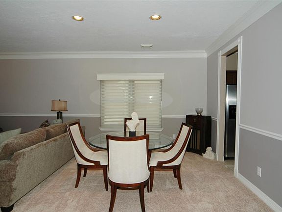 This is a close up view of the dining area with recessed lighting and custom window coverings.