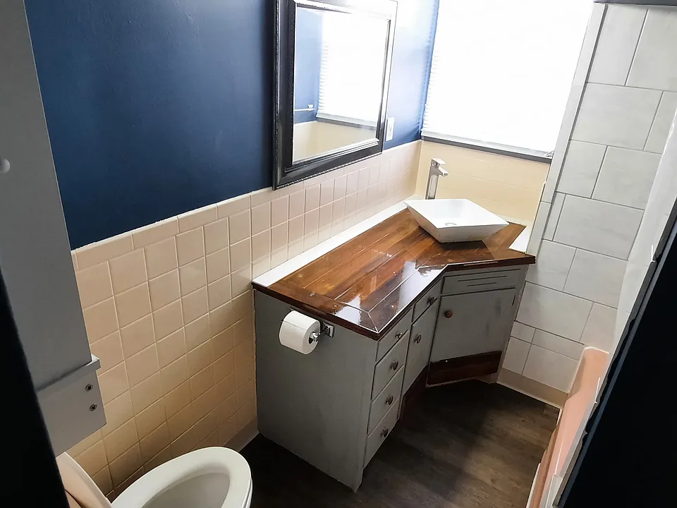 Bathroom with tub and tile surround, new flooring.