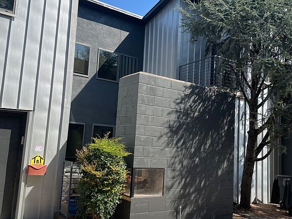 Driveway view of large patio and fireplace