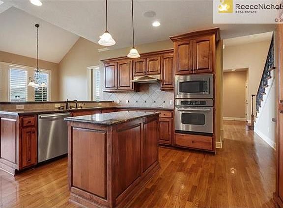 Expansive Corian Countertops, Granite Island w/pullouts, Travertine Backsplash, generous Walk-In Pantry, Stainless, & Breakfast Bar.