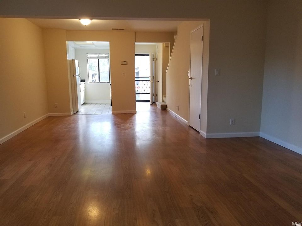 View from the patio shows front entrance, kitchen, 1/2 bath, storage closet. Wilson Art laminate wood floors, new paint.