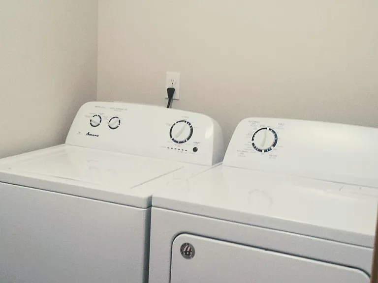 Washer and dryer in designated laundry room located upstairs.