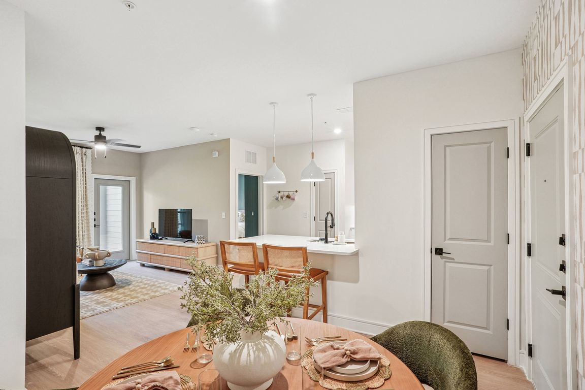 Dining Area and Kitchen Peninsula with Seating Space and View into Living Room