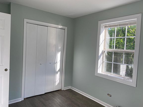 Bedroom has windows on two walls and a large closet. View from window to side yard with a small creek.