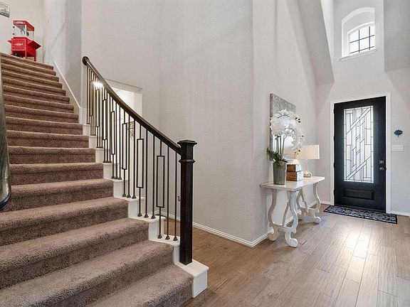 A view of the entry and stunning staircase with modern iron railings.