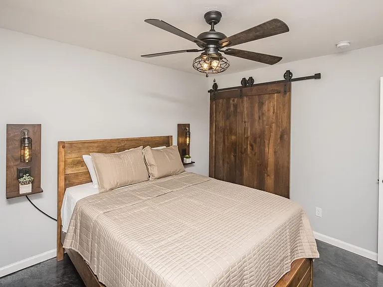 Bedroom view highlighting custom walnut sliding barn doors and clean architectural lines.
