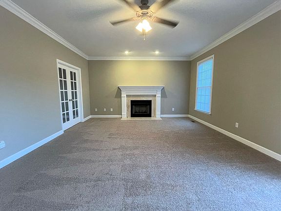 Family Room, with wood-burning fireplace, French doors and ceiling fan