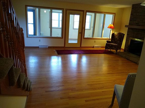 Living room with oak hardwood floors, four-season porch and private outdoor area.