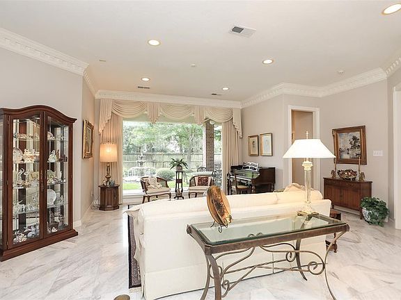 This is the amazing view as soon as you enter the home. The wall of windows in the formal living room looks out to the rear patio and fountain. Note the marble flooring, high ceilings and size of this room which will accommodate virtually any size fu