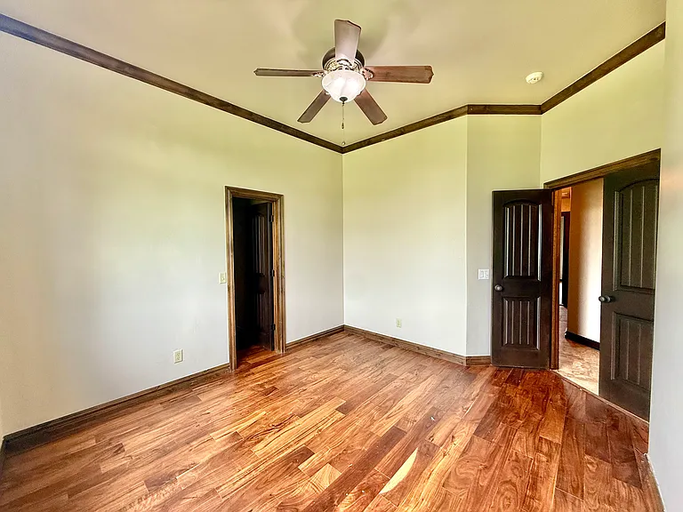 This second bedroom has multiple light sources, a fan, recess lighting and of course lots of natural light. Double French doors for ascetics.