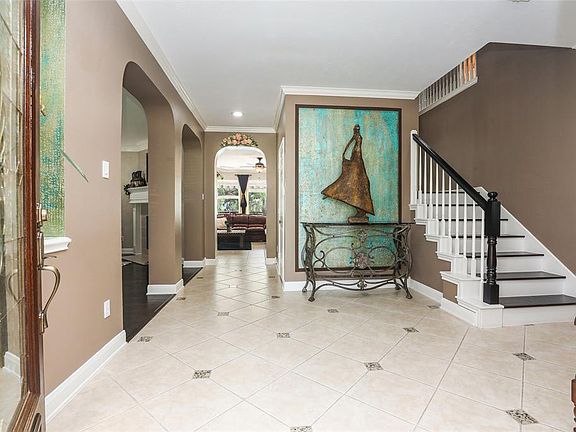 The entry is very welcoming with diagonally laid tile with granite inserts and art niches. To the left through the arches is the formal living room. Just out of this picture is the formal dining room on the right.