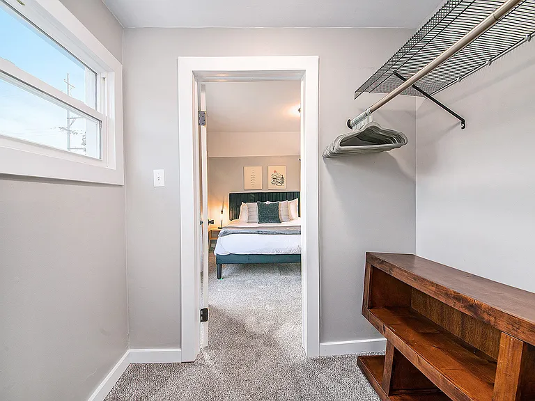 Jack and Jill closet between the two bedrooms. With hangers and a storage shelving unit