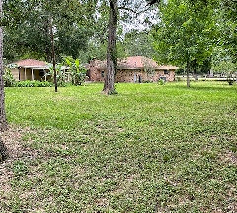 Backyard looking at house and garage with patio to left