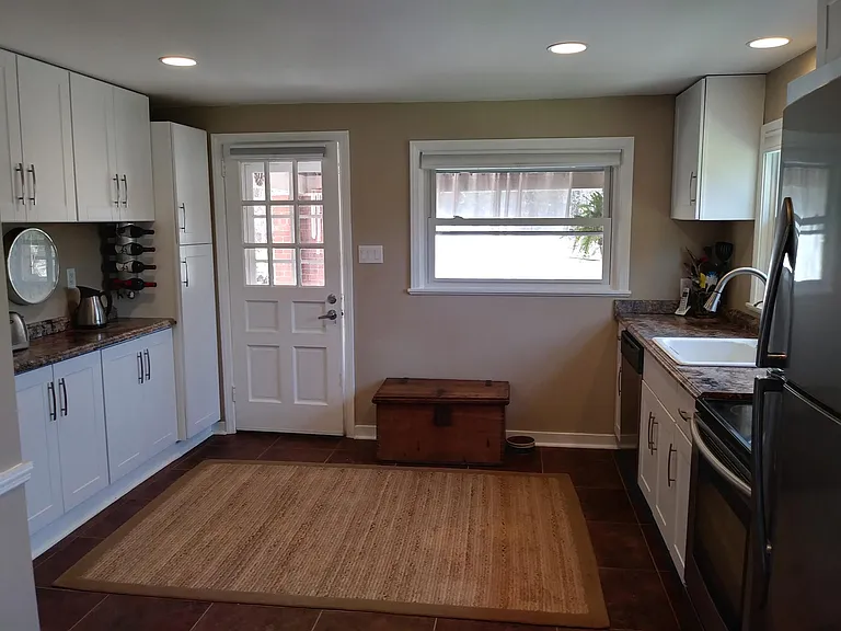 Kitchen with door to covered porch and open patio area.