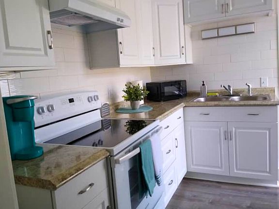 Fully equipped kitchen with stove, cabinets, and essential amenities.