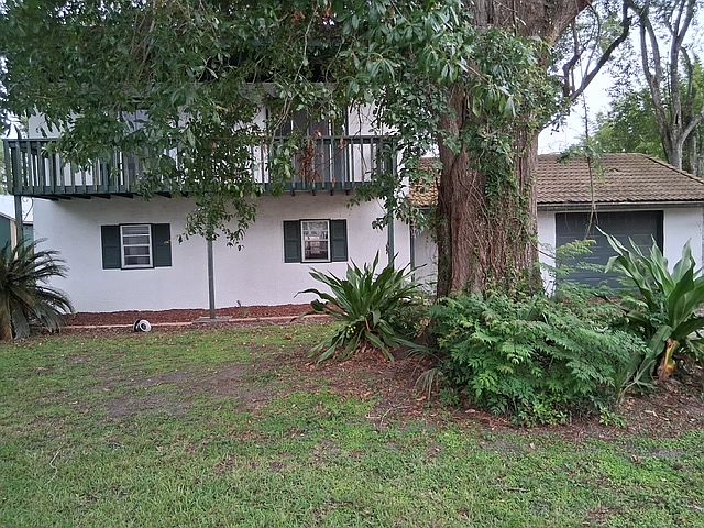A direct front view of the House, with he massive oak tree obscuring the covered entryway to the house.