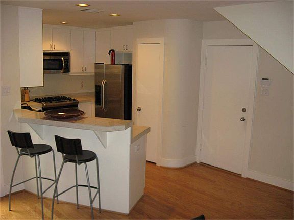 The kitchen and dining areas also have wood flooring, and the kitchen also has a breakfast bar, for 
