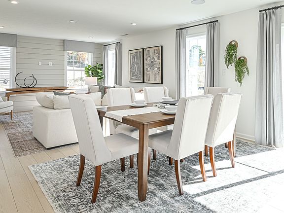 Open dining area and family room with 4 large windows on 2 walls, sliding glass door, and wood floor