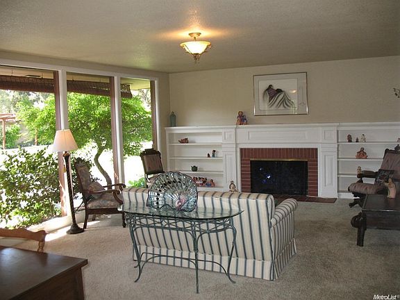 Gracious and inviting! The living room has picture windows overlooking a great patio and the beautiful grounds. Shelving flanks the fireplace an expansive mantel offers space for your collectibles.