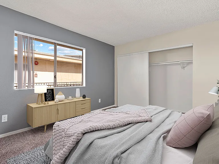 Carpeted bedroom with accent wall and large natural light window.
