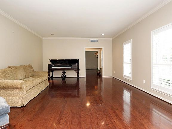 LIVING ROOM (21'x16') has wood floors, crown molding and two windows with shutters that allow views of the front yard.
