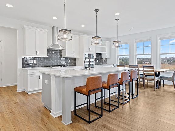 Open kitchen with large island in a DRB Homes Bridgeport Model at the Prinland Heights community.