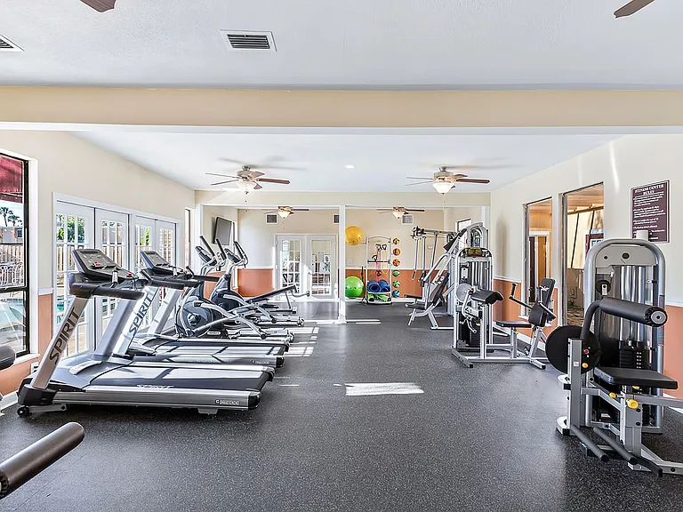 Bright, modern gym with state-of-the-art exercise equipment, cardio machines, and wellness spaces, perfect for an invigorating workout.